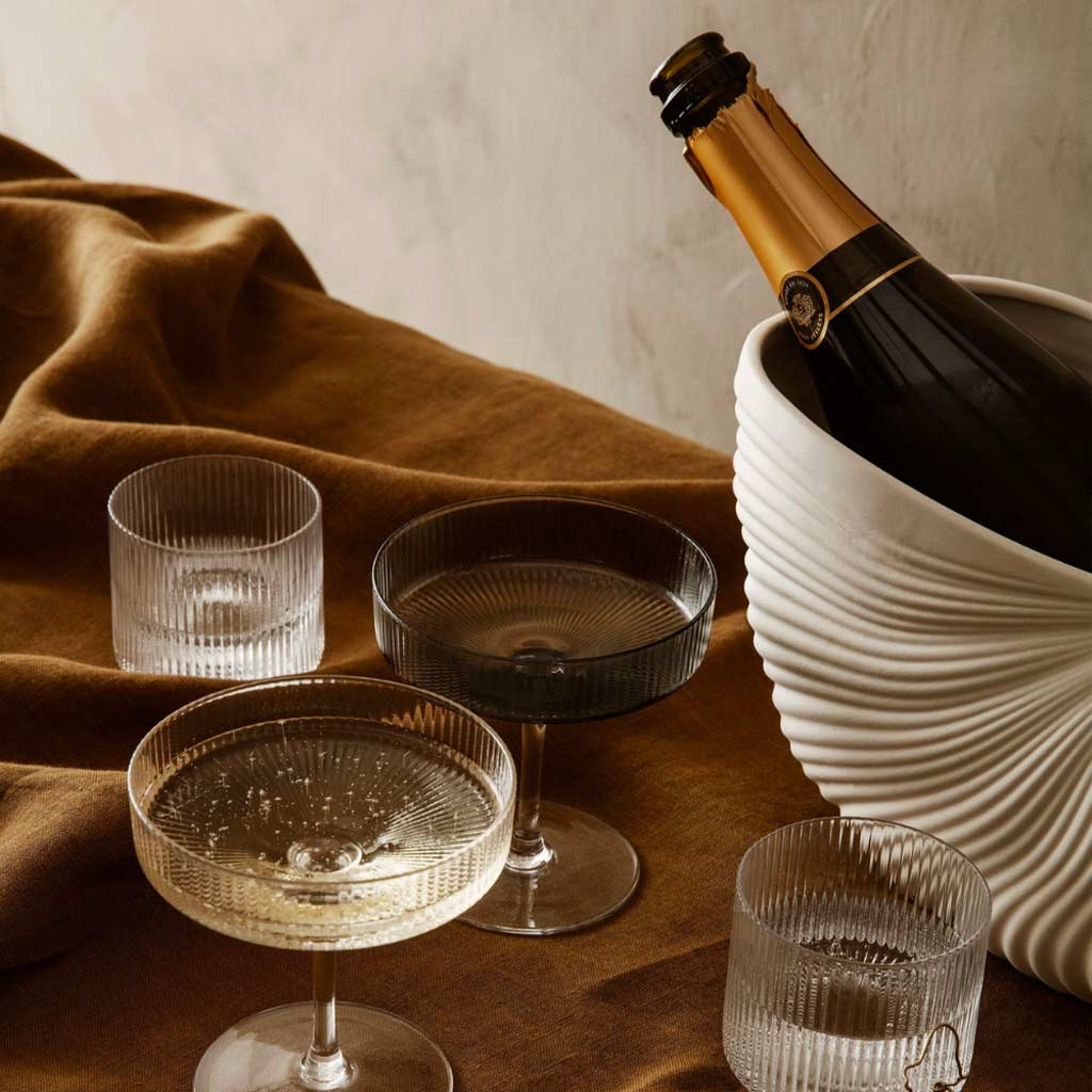 Le pot coquillage et des verres Ripple sur une table par l'Atelier Kumo